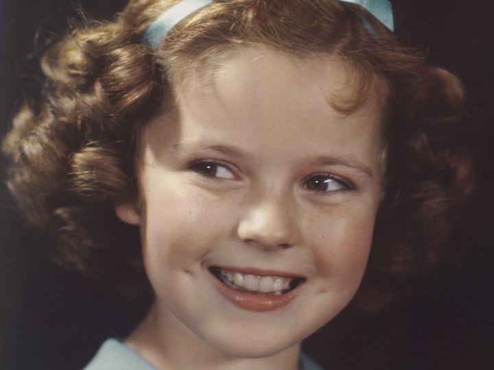 Color portrait of a young Shirley Temple with curly hair in 1938