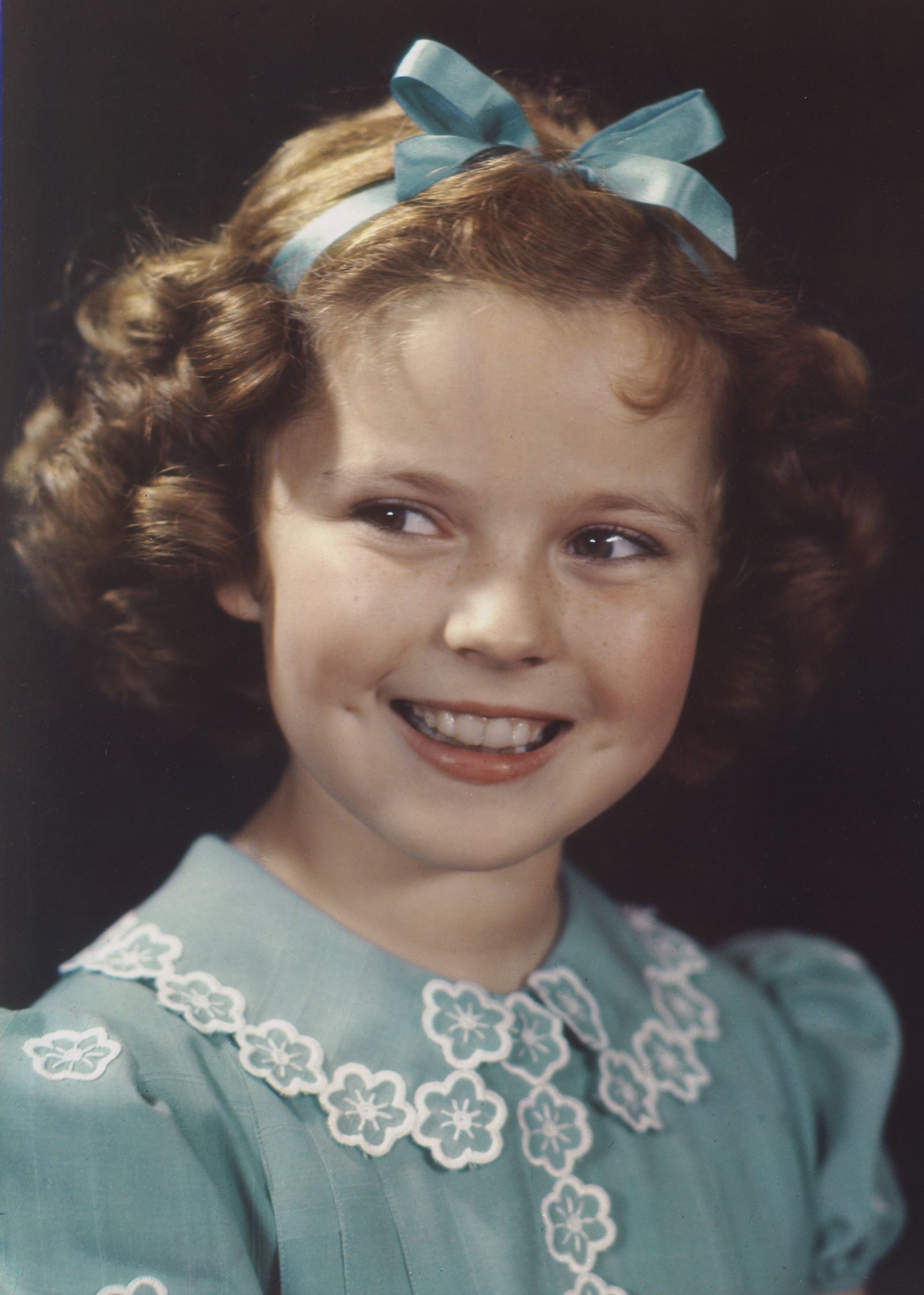 Color portrait of a young Shirley Temple with curly hair in 1938